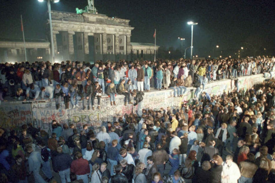 Menschen auf der Berliner Mauer vor dem Brandenburger Tor in der Nacht vom 9. auf den 10.11.1989. (Archivbild)