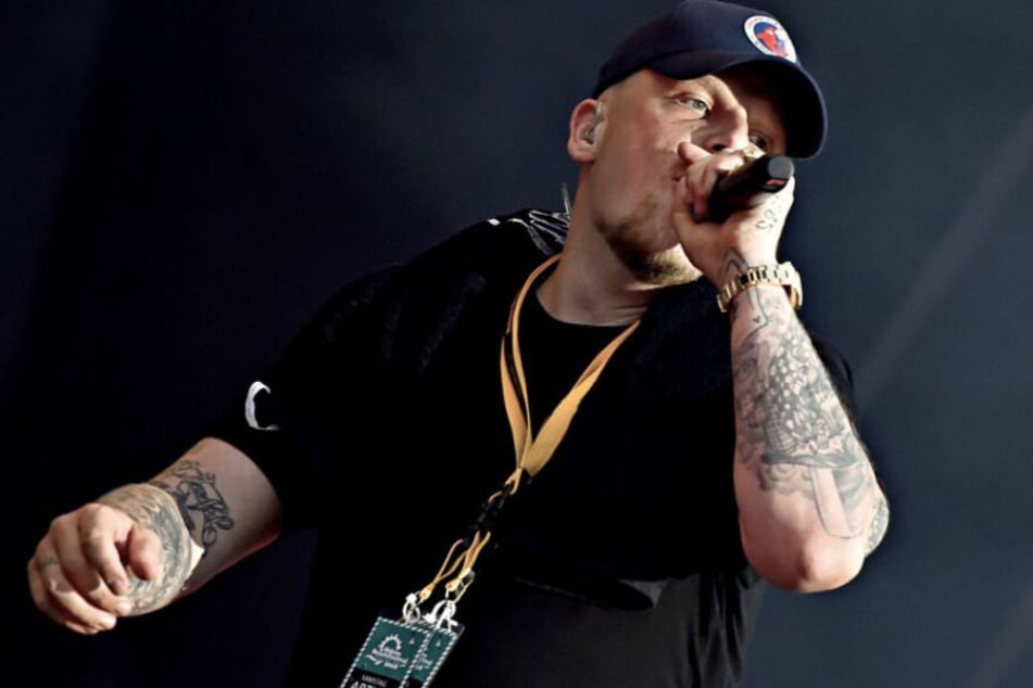 Bonez MC steht während eines Konzerts auf der Bühne.