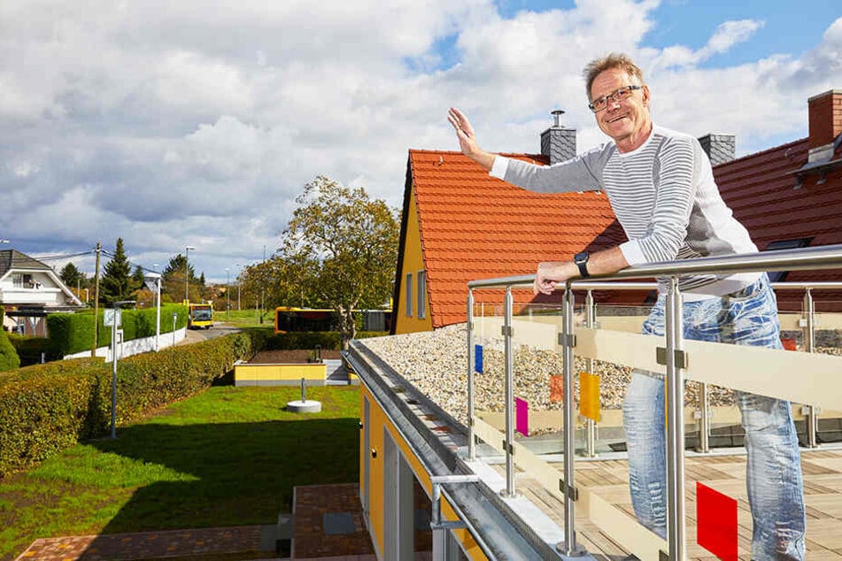 Frank (65) winkt von der Dachterrasse seinem Zwillingsbruder Wolle im gegenüberliegenden Haus zu.