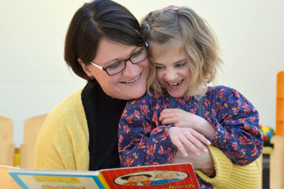 Frieda liest mit Mama Yvonne ein Buch.