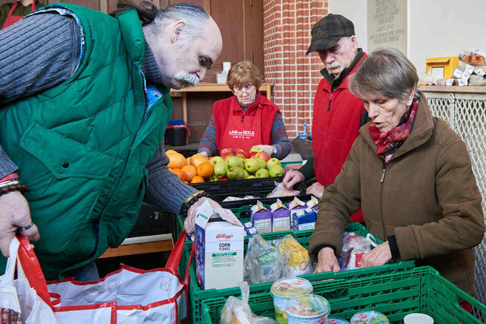 Ehrenamtliche helfen bei der Essensausgabe bei "Laib und Seele" in der Berlienr Advent-Zachäus Kirche.