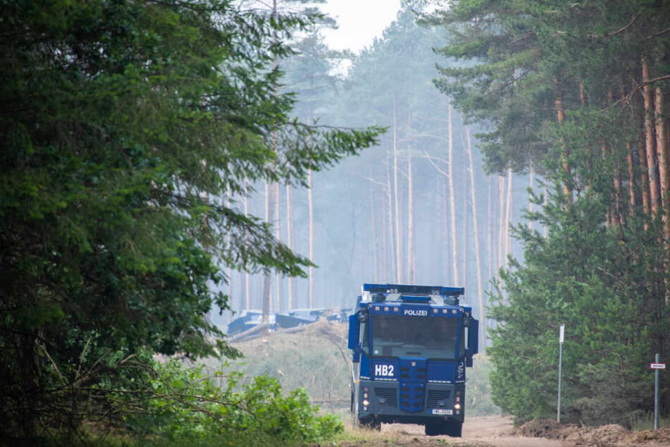 Ein Wasserwerfer der Polizei ist bei den Löscharbeiten im Einsatz.
