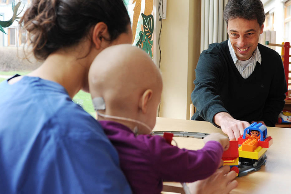 Der Hamburger Kinderonkologe Prof. Stefan Rutkowski mit einer Krankenpflegerin und einem am Krebs erkrankten Kind im Spielzimmer des Universitätskrankenhaus Hamburg-Eppendorf (UKE).