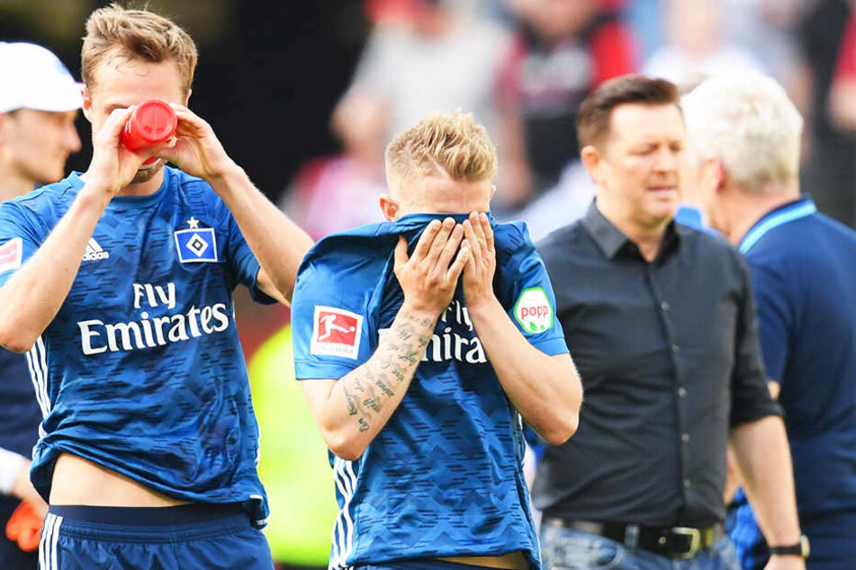 HSV-Spieler Matti Steinmann (l.), Lewis Holtby (m.) und Trainer Christian Titz sind nach der Niederlage in Frankfurt fassungslos.