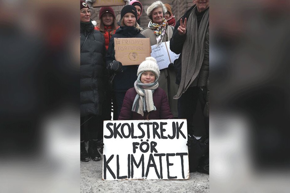 Greta demonstriert vor dem Reichstag in Stockholm für mehr Klimaschutz mit dem Plakat "skolstrejk for klimatet" (Schulstreik für das Klima).