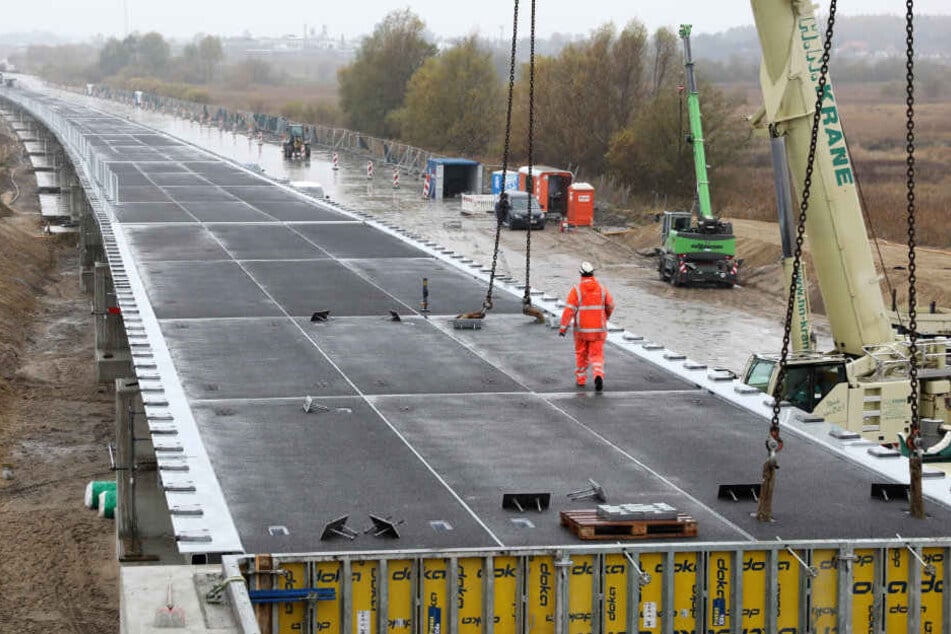 An der Behelfsbrücke für die abgesackte A20 wird das letzte Bauteil verlegt.