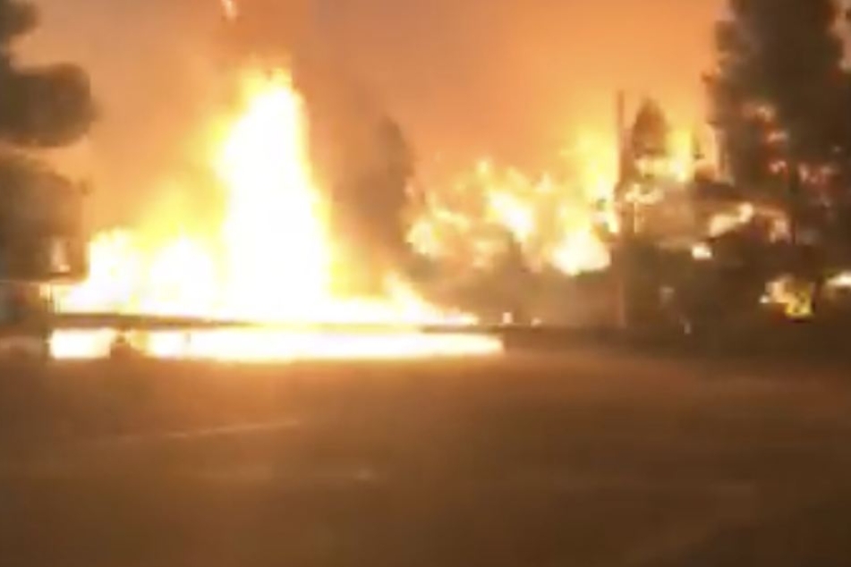 Eine Frau filmt aus dem Auto heraus die Fahrt durch die Feuerhölle.