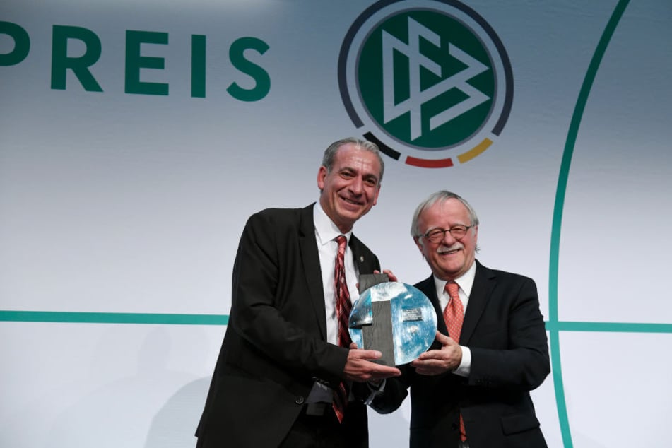 Verani Kartum (li.), der Vereinsvorsitzende vom Preisträger SC Aleviten Paderborn, bekommt den Julius Hirsch Preis von Laudator Hans Leyendecker überreicht.