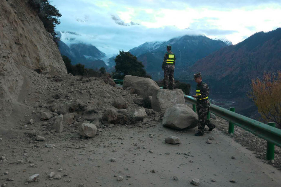 Eine Straße im Kreis Mainling im autonomen Gebiet Tibet ist nach einem Erdbeben durch herabgestürzte Felsbrocken blockiert.