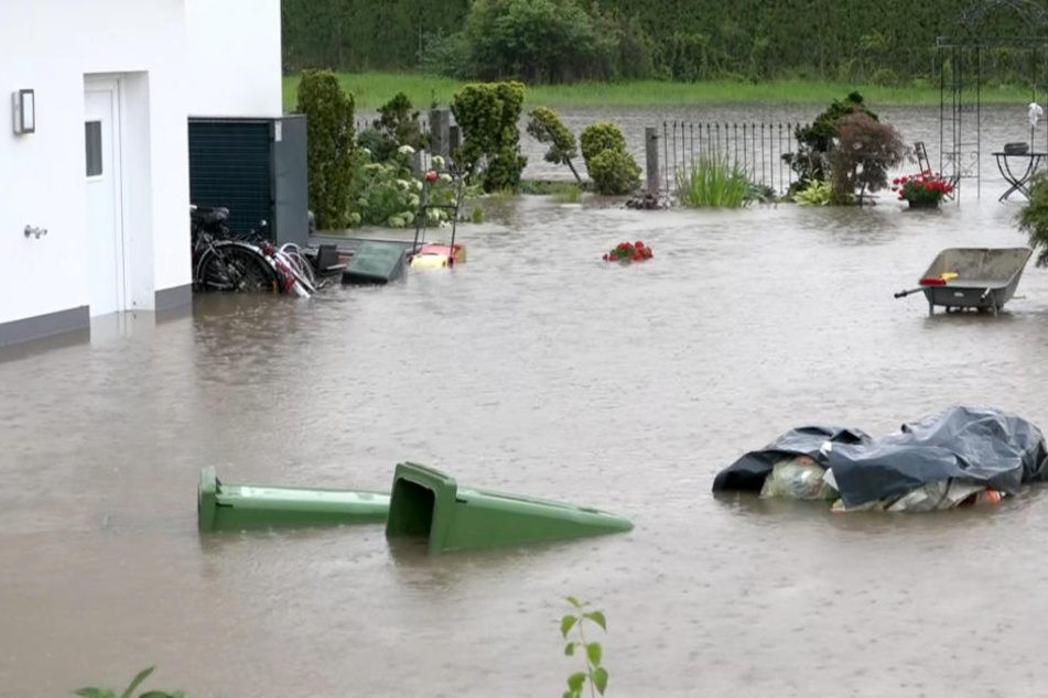Nach einem Starkregen ist der Vorgarten eines Hauses in Bayern überschwemmt.
