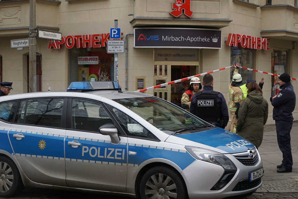 Polizisten sichern den Bereich rund um die Apotheke.
