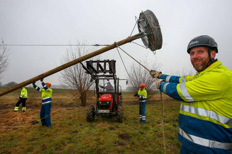 Fünf Männer der Stadtwerke bauen den Mast auf.
