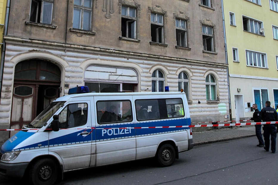 Die Polizei steht vor dem Mehrfamilienhaus in Rathenow, in dem die Feuerwehr nach einem Brand zwei Leichen entdeckt hat.