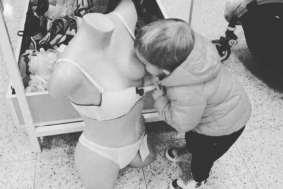 Ein kleiner Junge zieht den BH einer Puppe herunter und versucht, an der Plastik-Brust zu saugen. Dieses Bild postete Anna-Maria Zimmermann auf Instagram.