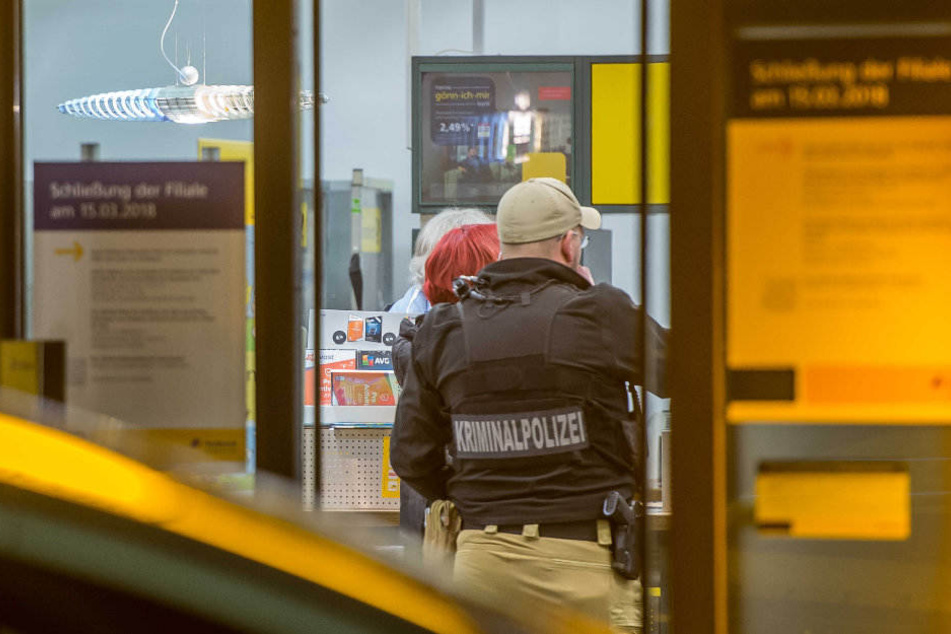 Kriminalpolizisten suchen den Tatort auf mögliche Spuren ab.