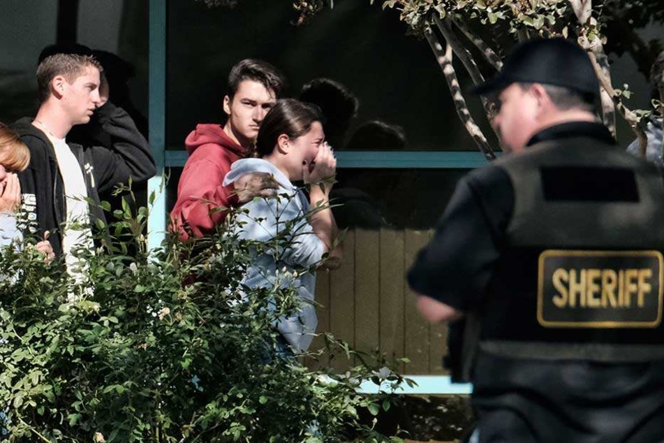 Trauernde werden in das Thousand Oaks Teen Center geführt, wo sich Familien nach einer tödlichen Schießerei in einer Bar versammelt haben.