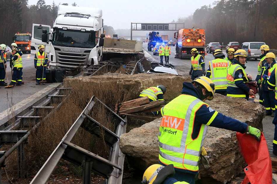 Einsatzkräfte arbeiten am Mittwoch an einer Unfallstelle auf der Autobahn 3 bei Nürnberg (Bayern). Ein mit Felsbrocken beladener Lkw war zwischen den Anschlussstellen Nürnberg-Nord und Behringersdorf verunglückt und hatte die Mittelleitplanke durchbrochen