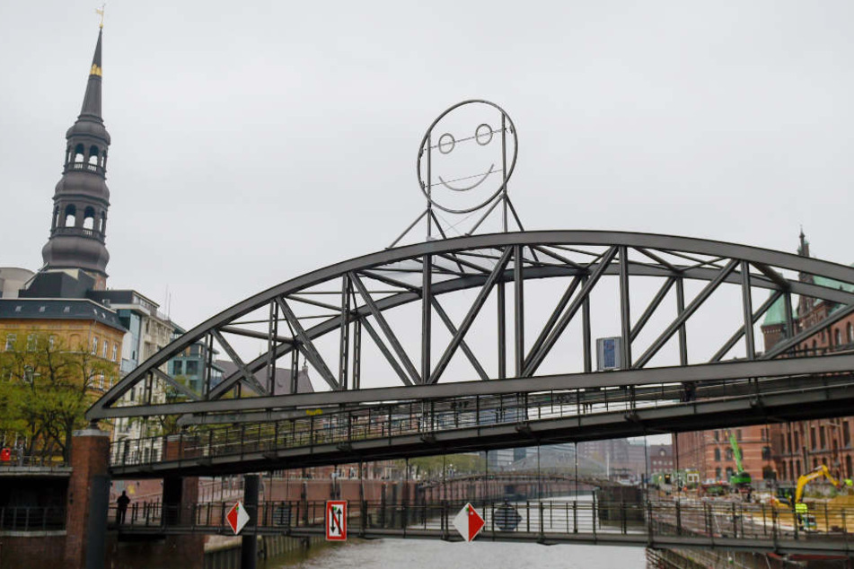 Die mehrere Meter hohe Smiley-Skulptur aus Stahl und Neonröhren steht auf der Brücke am Kibbelsteg.