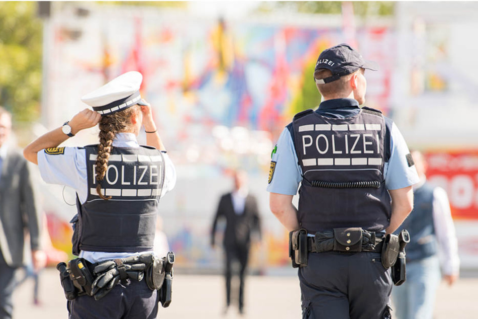Polizeibeamte gehen bei der Eröffnung des 172. Cannstatter Volksfests in Stuttgart (Baden-Württemberg) über das Volksfestgelände.