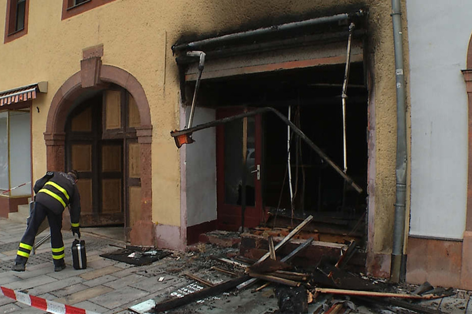 Die Brandursachenermittler der Polizei untersuchen den vom Feuer zerstörten Laden.
