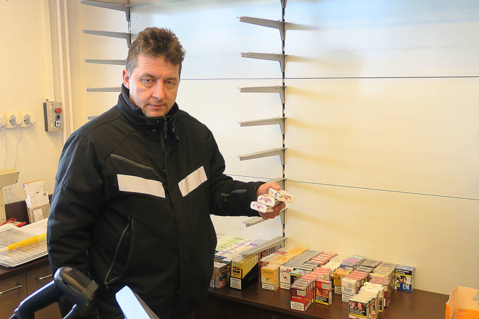 Pächter Jan Jacob vor dem leeren Zigarettenregal in sein er Tankstelle.