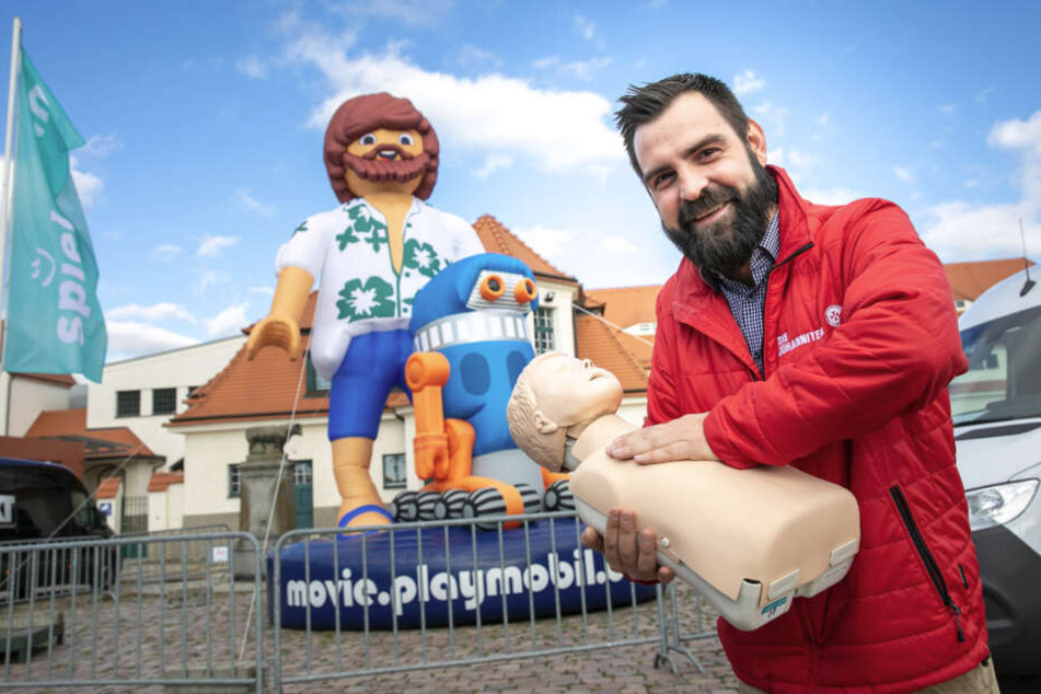 Spielerisch lernen: Danilo Schulz (36) von den Johannitern zeigt die Junior-Reanimationspuppe, die vor Ort ausprobiert werden kann.