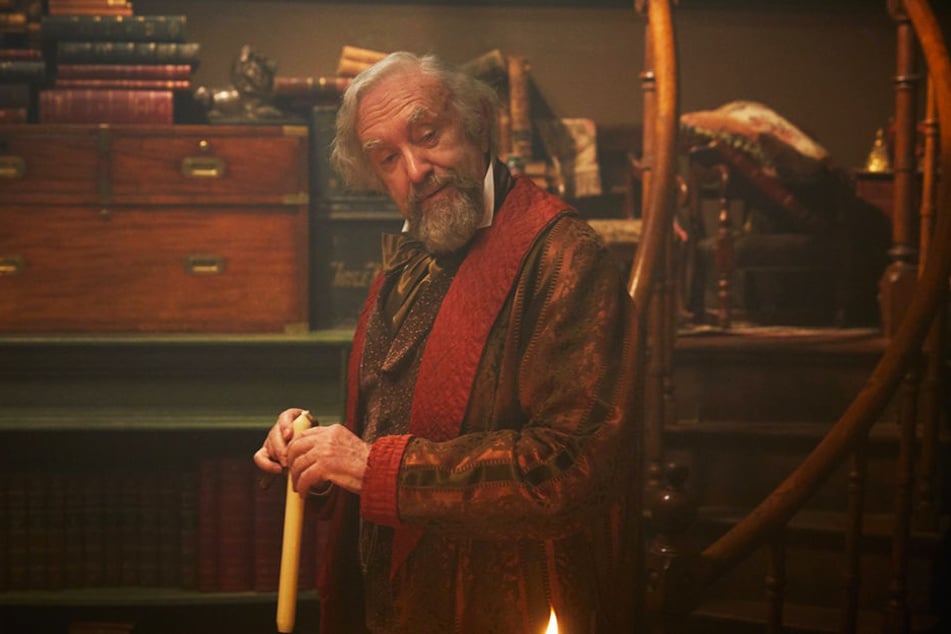 John Dickens (Jonathan Pryce) ist ein herzensguter, aber auch verschwenderischer Mensch, der seinen Sohn immer wieder bei der Arbeit unterbricht.