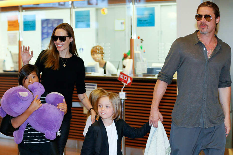 Die US-Schauspielerin Angelina Jolie und Mann Brad Pitt kommen mit ihren Kindern Pax Thien (l), Shiloh (verdeckt) und Knox Jolie-Pitt am 28.07.2013 in Tokyo am Internationalen Flughafen Haneda an.