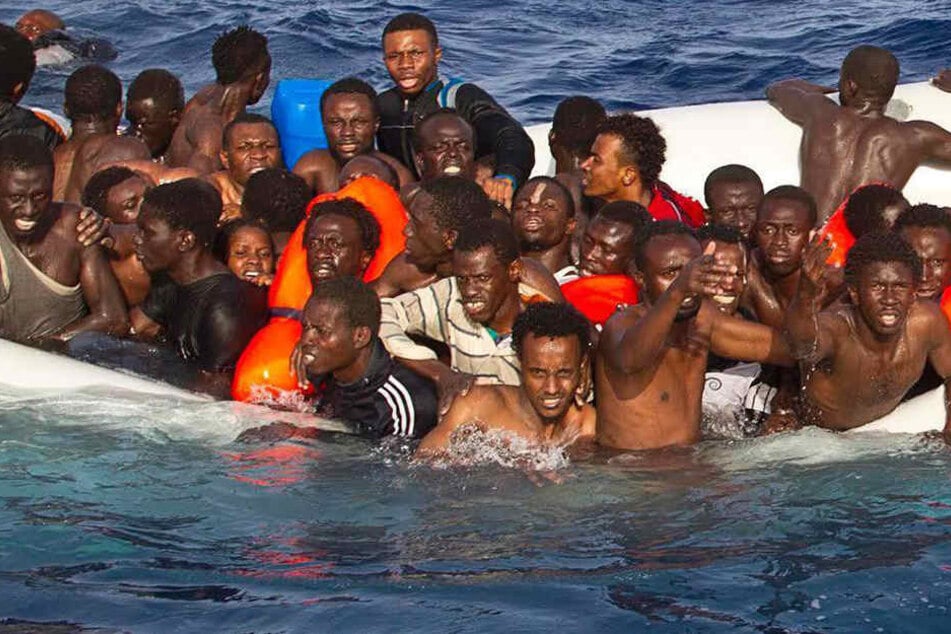 Flüchtlinge auf dem Mittelmeer in einem sinkenden Schlauchboot.