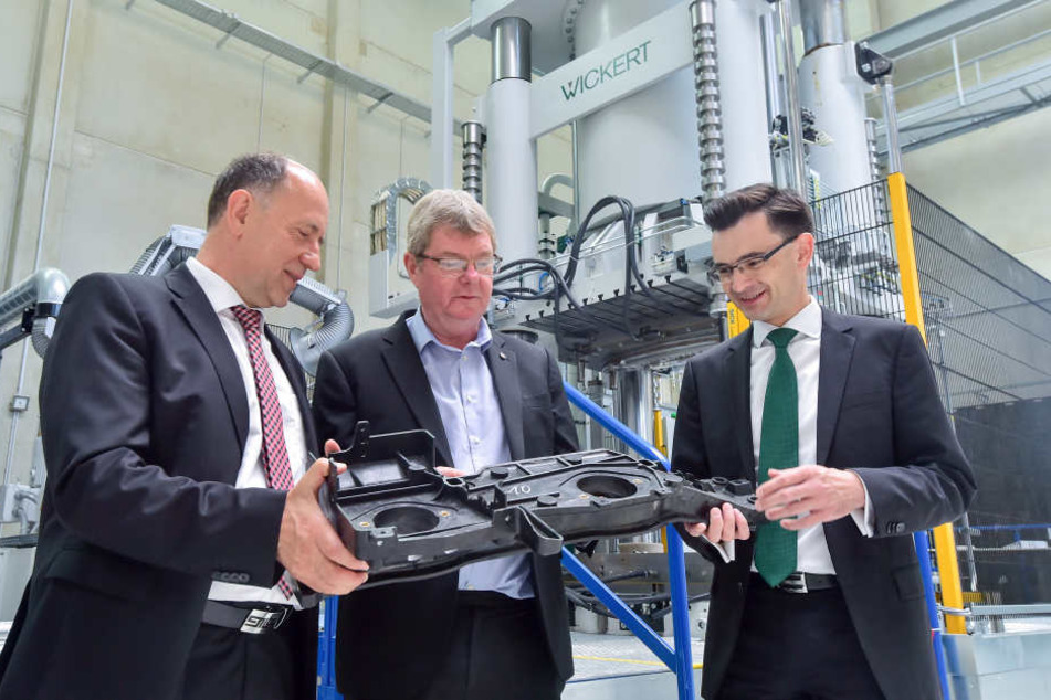 Gerd Strohmeier (r), Rektor der Technische Universität Chemnitz und MERGE-Koordinator Lothar Kroll (l) verdeutlichten David Cardwell von der University of Cambridge in der MERGE-Forschungshalle einen Leichtbau-Motorträger der Forschung am Chemnitzer Bunde
