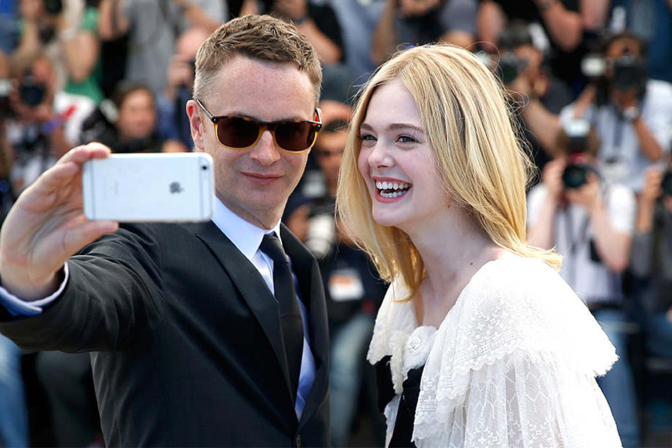 Die amerikanische Schauspielerin Elle Fanning und der dänische Regisseur Nicolas Winding Refn machen trotzdem ein Selfie von sich.