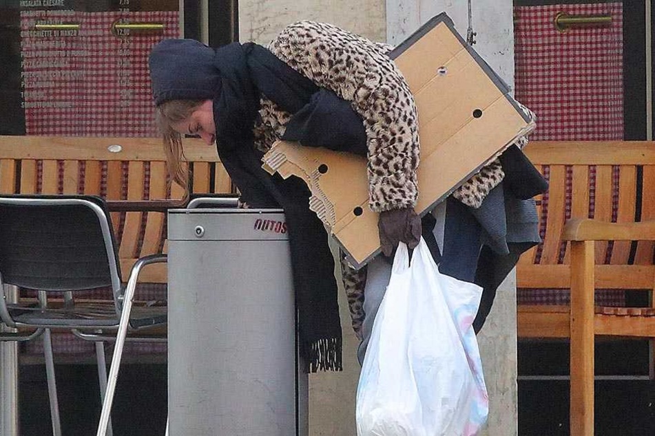 Mit Schal, Pappe und Schlafsack unterwegs: Mülleimer nach Brauchbarem zu durchwühlen ist sogar noch ekliger, als man es sich vorstellt.
