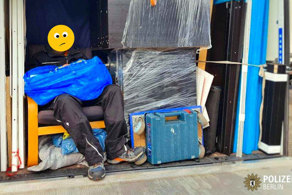Auf der Ladefläche eingepfercht, sitzt der Mann auf einem Polstersessel.