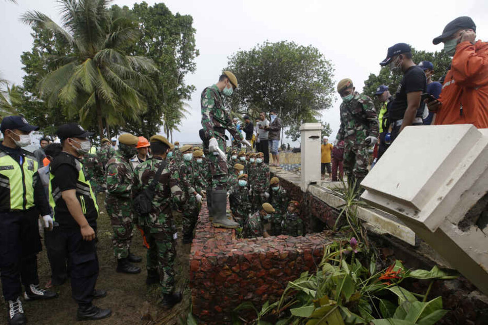 Indonesische Soldaten ud Rettungskräfte suchen in einem Strandressort nach Opfern der Tsunami-Katastrophe.