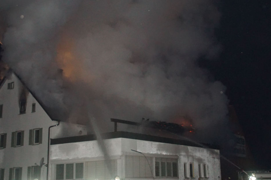 Die Feuerwehr löscht das brennende Wohn-und Geschäftsgebäude.