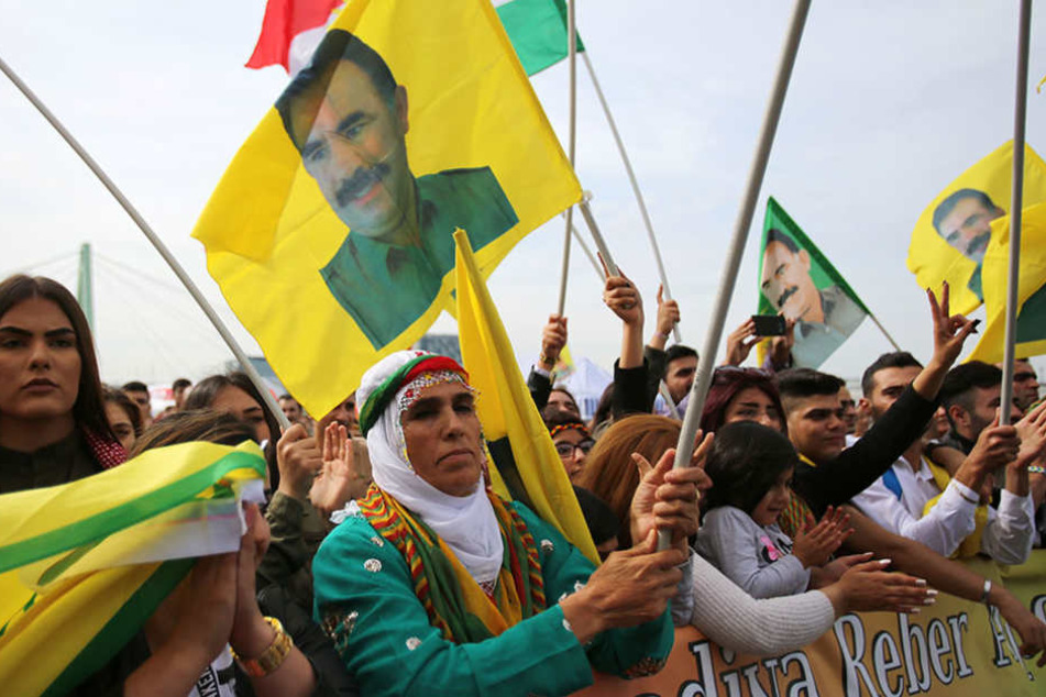 Teilnehmer der Kundgebung schwenken Fahnen mit dem Bild des PKK-Gründers Öcalan.