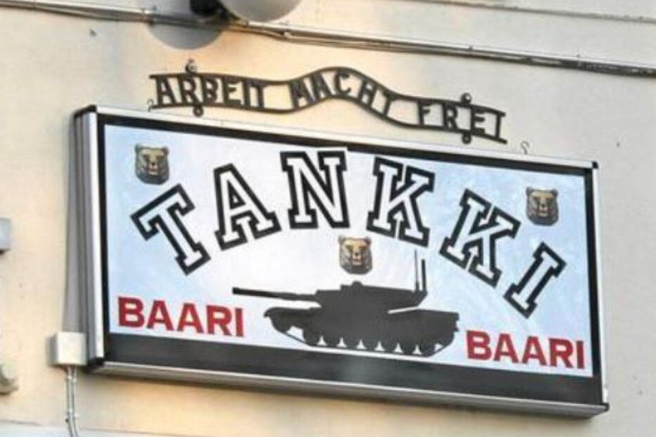 Über dem Kneipen-Schild prangt der Satz "Arbeit macht frei"