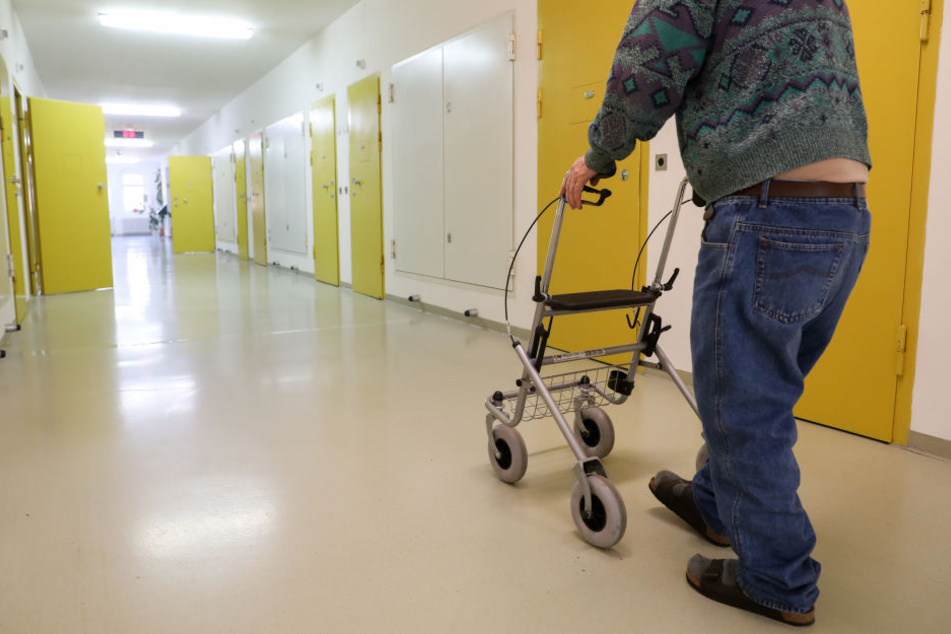 Ein Häftling im Rentenalter geht mit einem Rollator über den Flur im Seniorentrakt der JVA Waldheim.