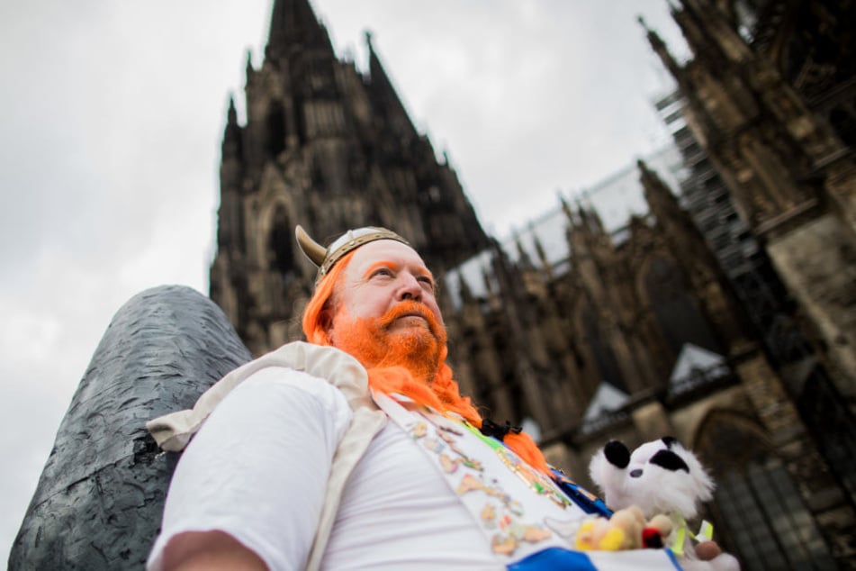 Ein Jeck verkleidet als "Obelix" feiert den Auftakt der Karnevalssession vor dem Dom.
