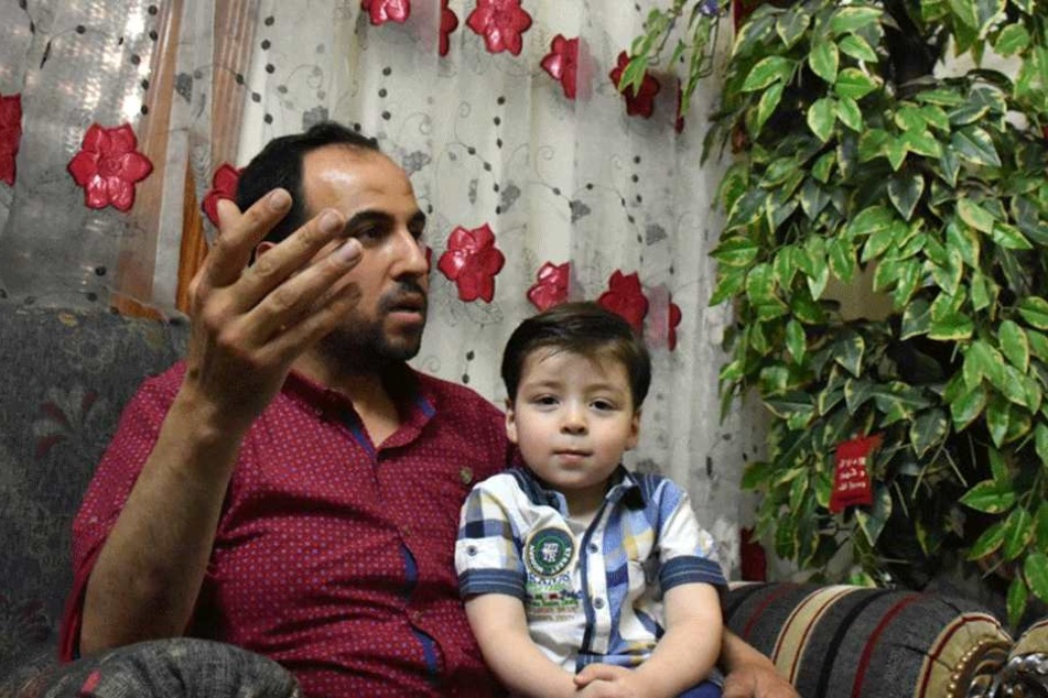 Der kleine Omran sitzt auf dem Schoß von Vater Mohammed Daknisch.