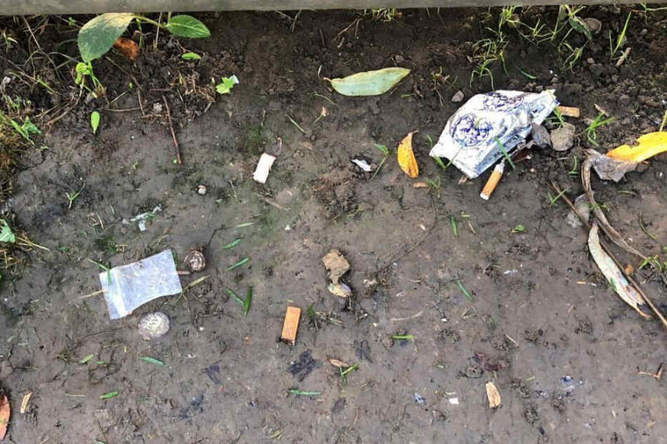 Überall liegt achtlos weggeworfener Müll herum, der auf Drogenkonsum hinweist.