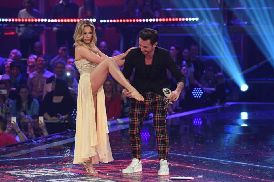 Florian zieht seiner Freundin Helene die Schuhe aus.