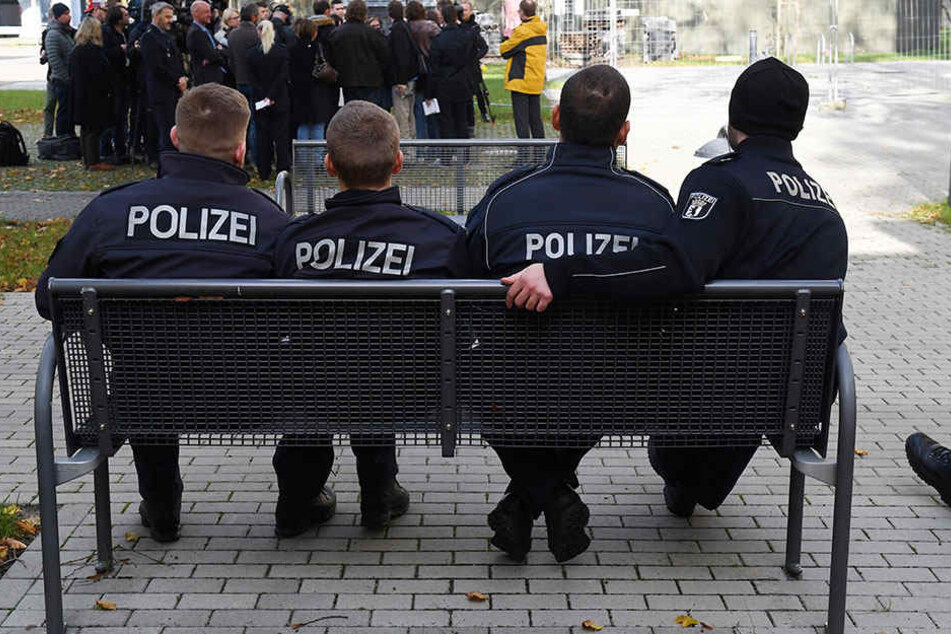 Berliner Polizeischüler auf einer Bank vor einem Ausbildungsgebäude.