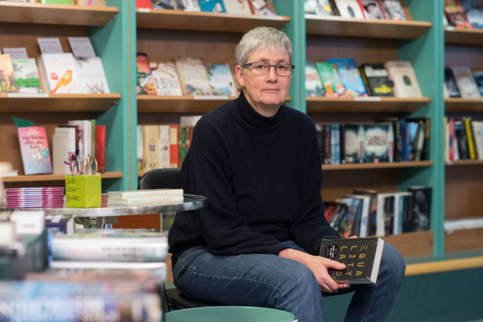 Die Inhaberin der Buchhandlung Schiller, Susanne Martin, sitztin Stuttgart hinter Büchern.