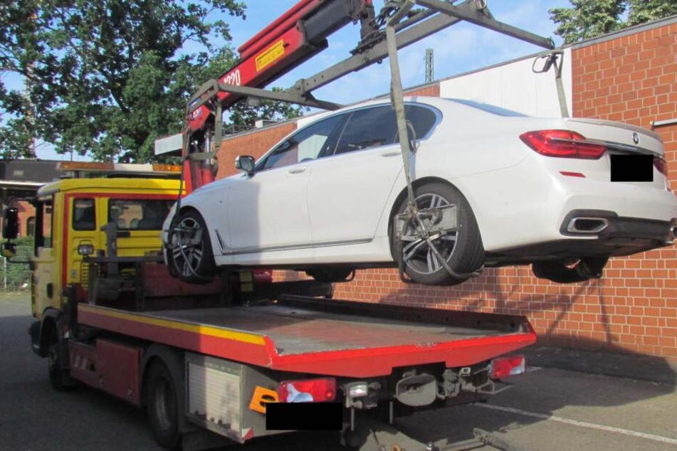 Ein gepfändeter, hochwertiger BMW wird nach der Razzia abgeschleppt.