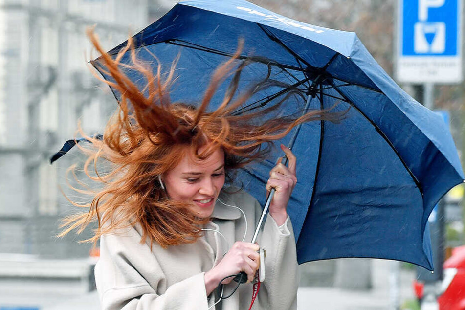 Gegen Sturm und Regen kämpft eine junge Frau hier an.