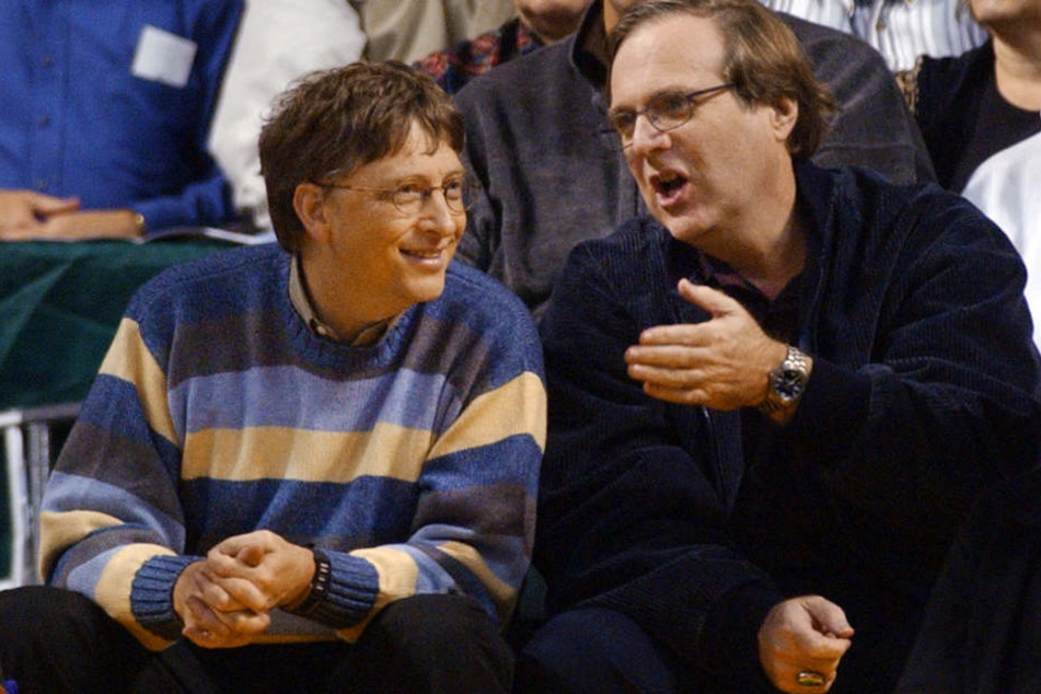 Bill Gates (l) und Paul Allen, beide Gründer von Microsoft, sitzen während eines Basketball-Spiels im Jahr 2003 nebeneinander.