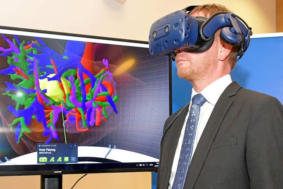 Ministerpräsident Michael Kretschmer (44, CDU) trägt im Nationalen Zentrum für Strahlenforschung in der Onkologie eine Virtual-Reality-Brille und betrachtet eine vom Krebs befallene Leber.