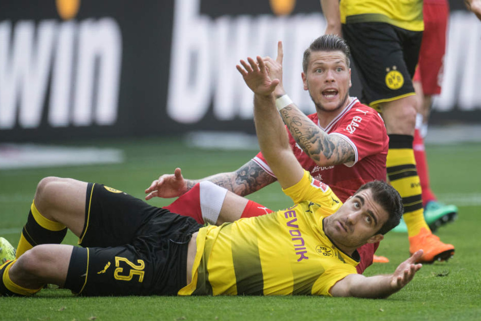 Dortmunds Sokratis (vorne) und Daniel Ginczek von Stuttgart landen nach einem Zweikampf auf dem Rasen.