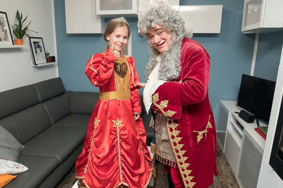 August der Starke hat zum Hausbesuch bei Annabell Lina das Kleid der Pfefferkuchenprinzessin mitgebracht. Es muss bis zur Krönung noch gekürzt werden.